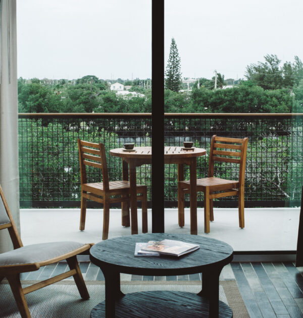 Hotel balcony with wooden table and forest view.