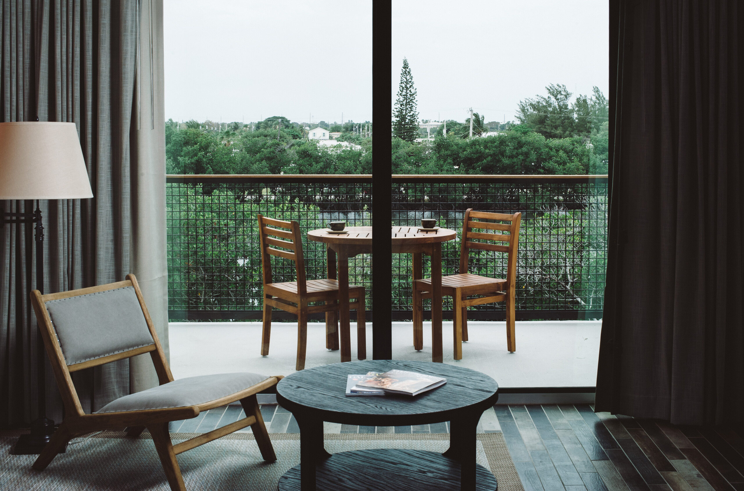 Hotel balcony with wooden table and forest view.