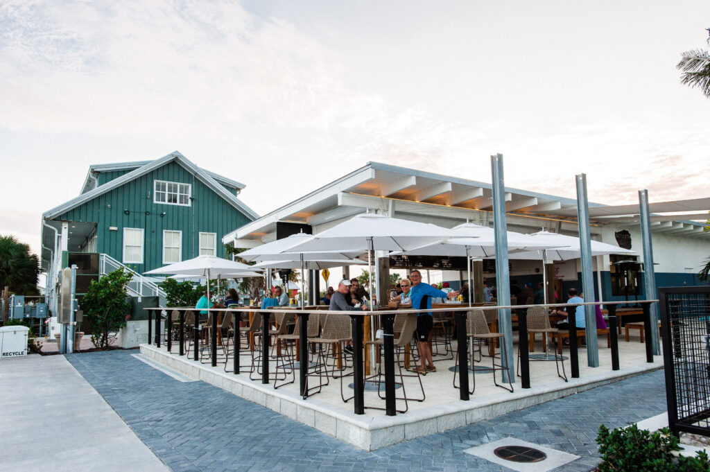 Outdoor bar with umbrellas and guests dining.