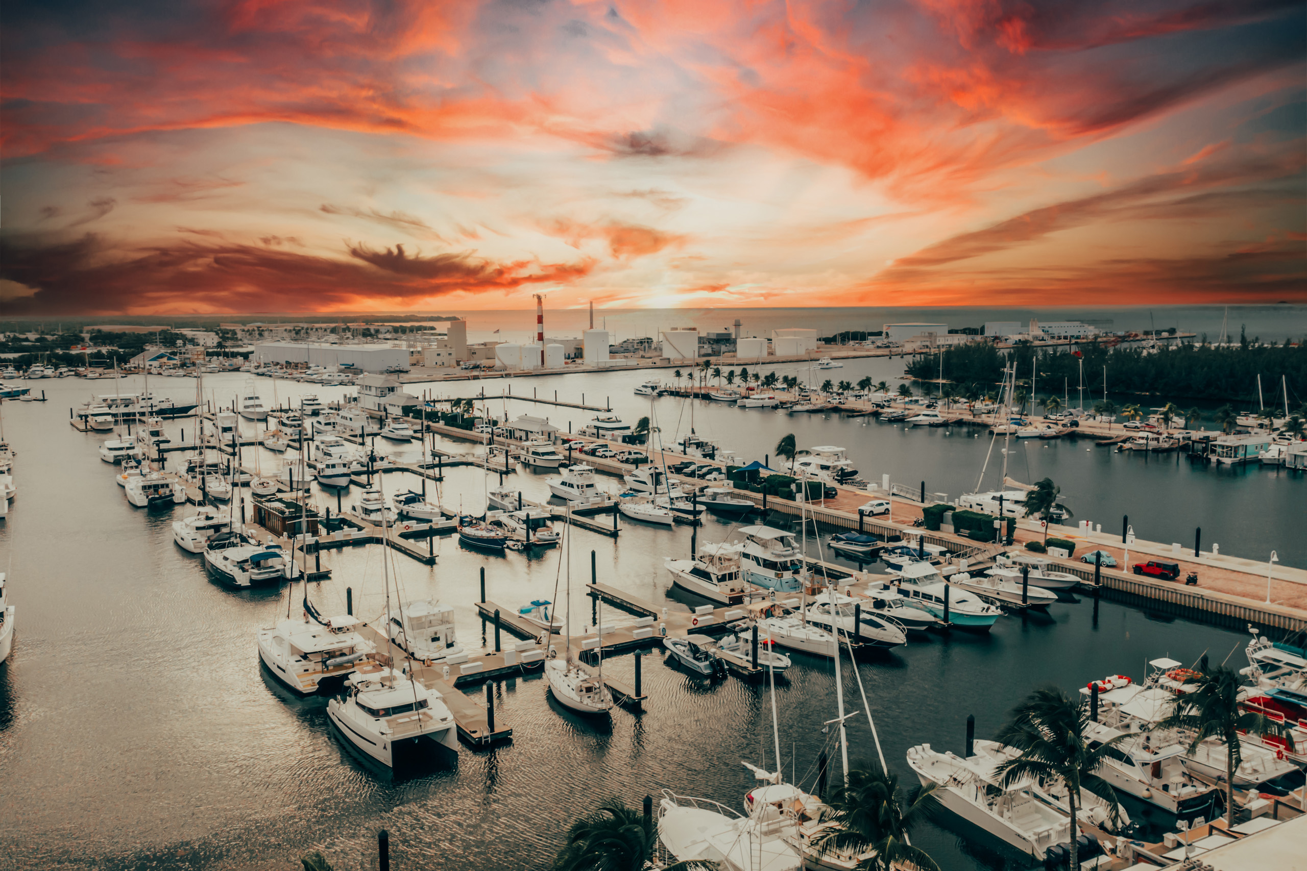 Sunset sky over marina filled with docked boats.