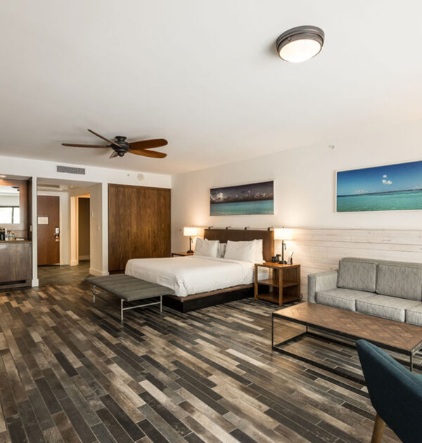King suite view showing sofa, desk, wet bar, and wood accents.