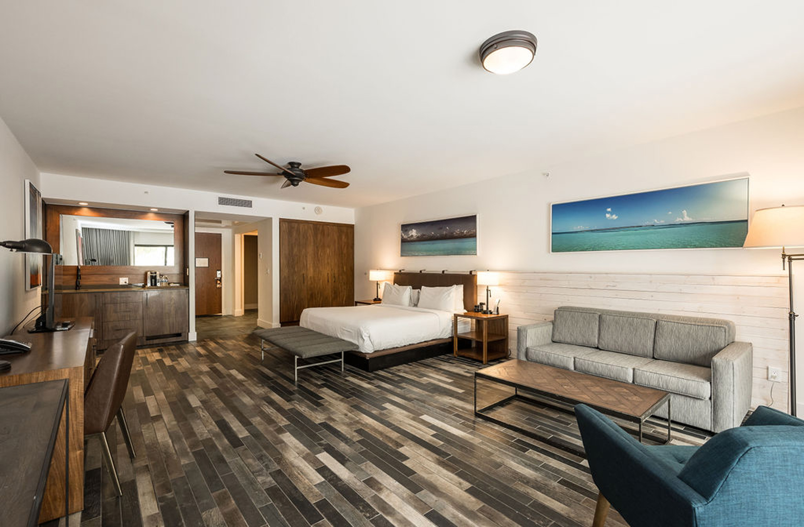 King suite view showing sofa, desk, wet bar, and wood accents.