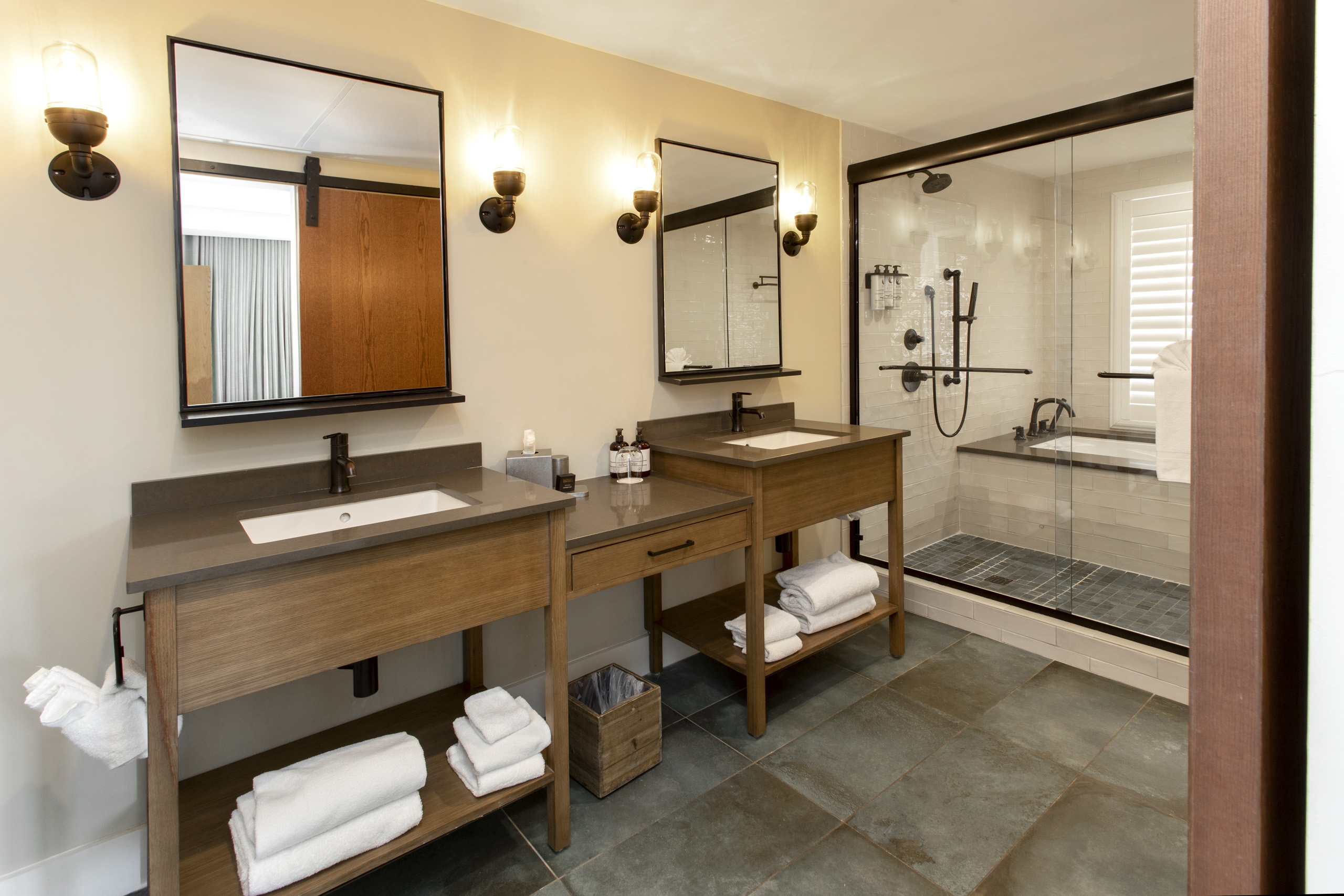 Spacious bathroom with dual sinks, mirrors, and glass-enclosed shower.