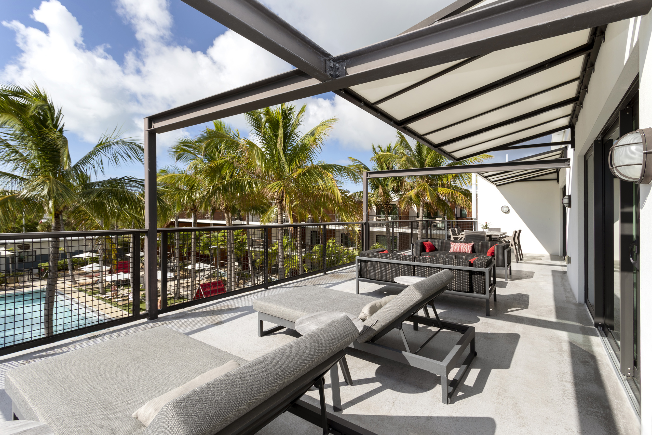 Expansive terrace with loungers, outdoor seating, and palm tree views.