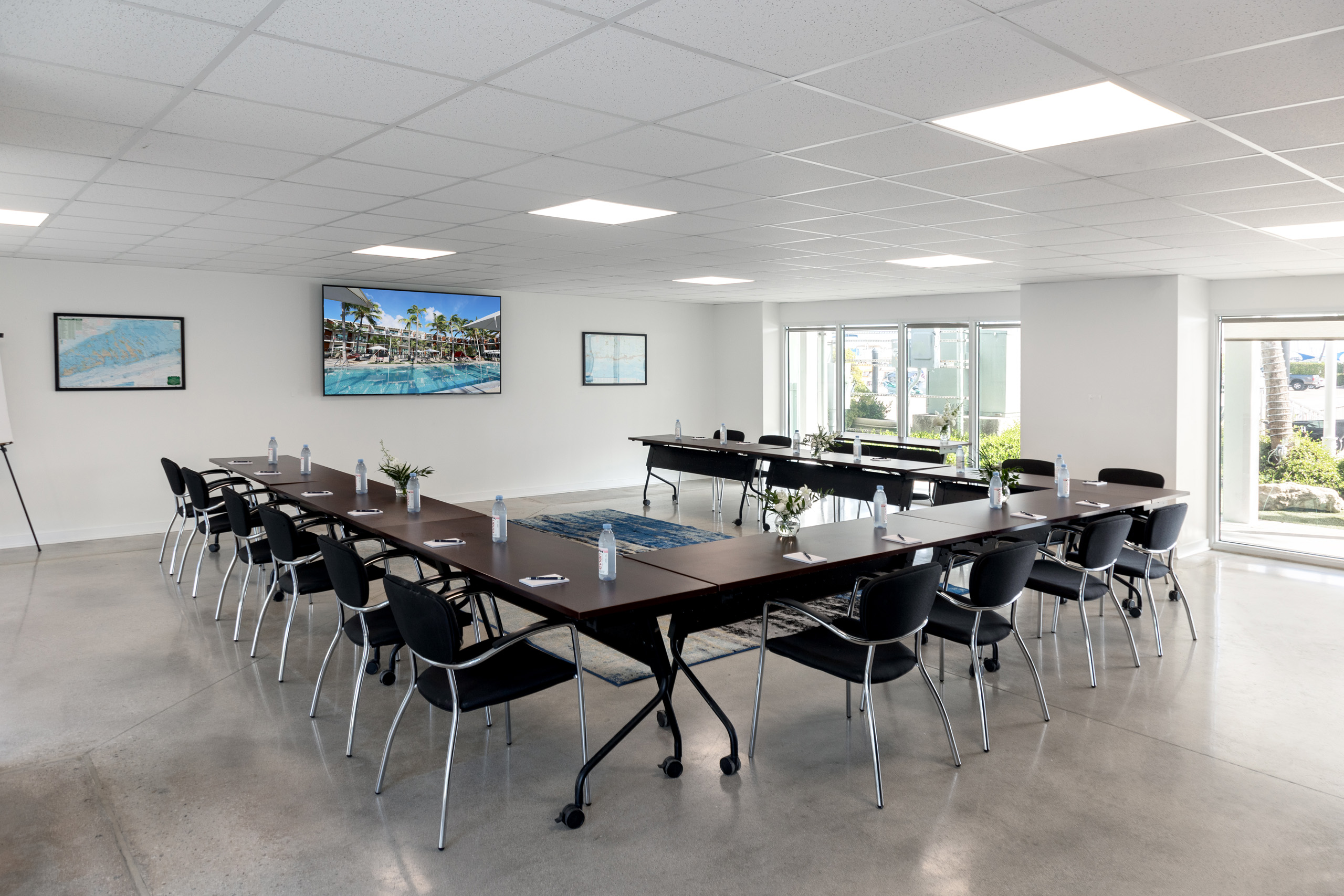 Bright, modern meeting space with U-shaped table setup.