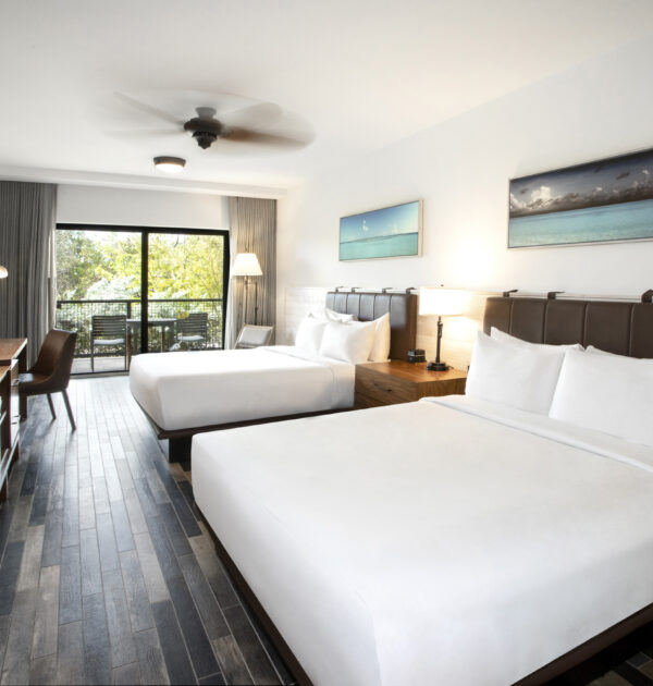 Spacious room with two queen beds, desk, TV, and balcony view.