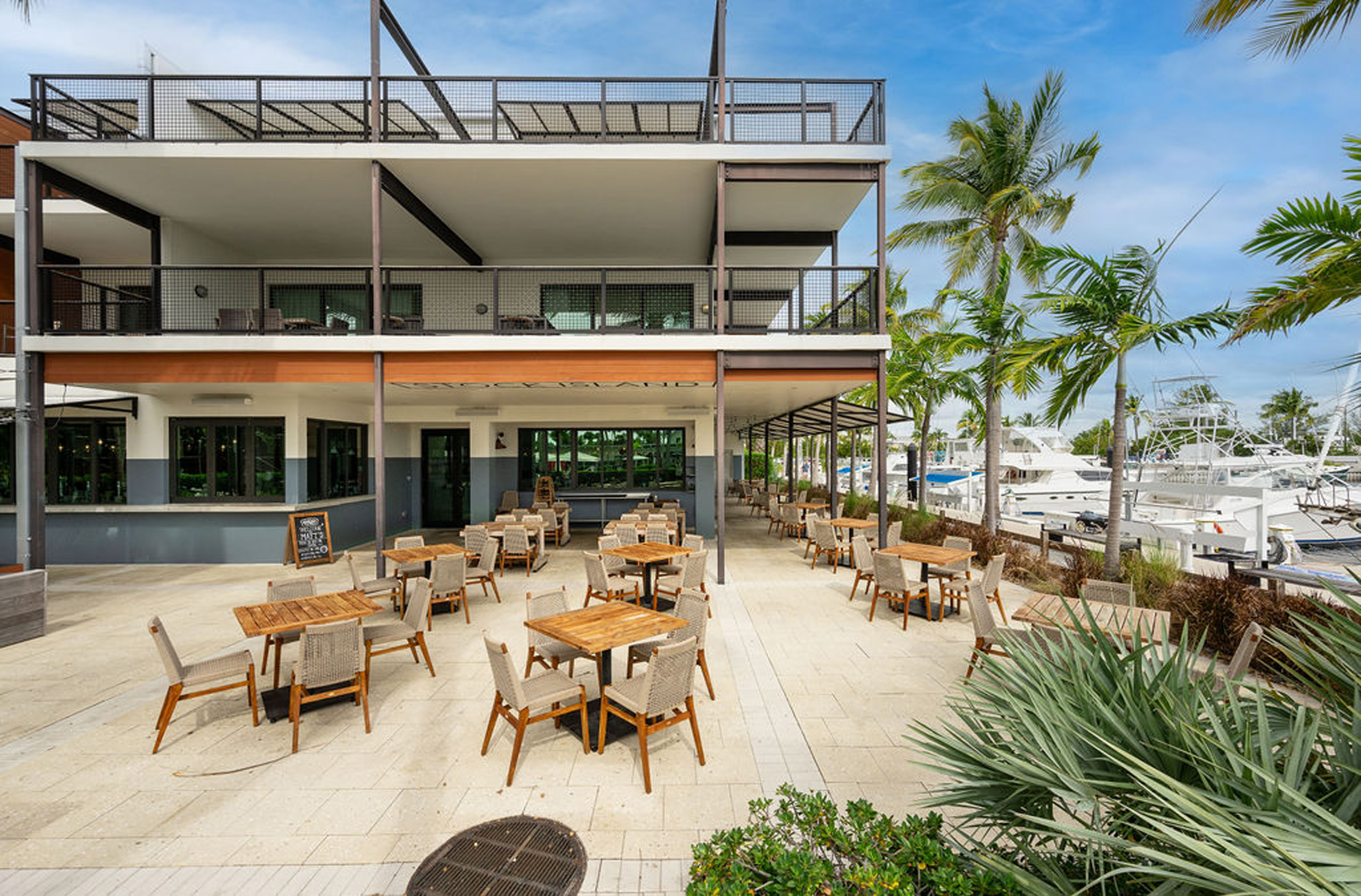 Patio dining area with tables and marina views.