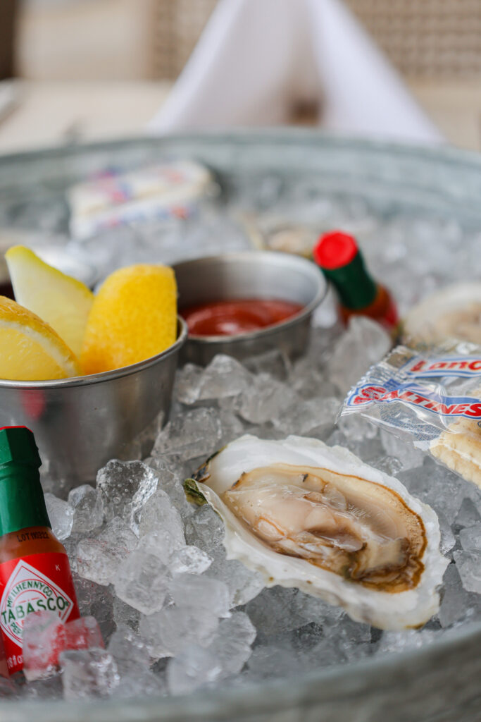 Fresh oysters on ice with lemon, Tabasco, and crackers.
