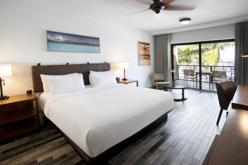 Spacious king guest room with balcony and marina views.