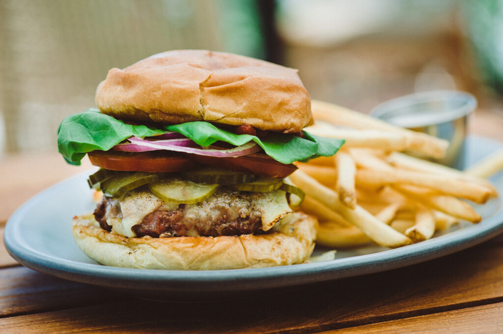 Burger with lettuce, tomato, and fries.