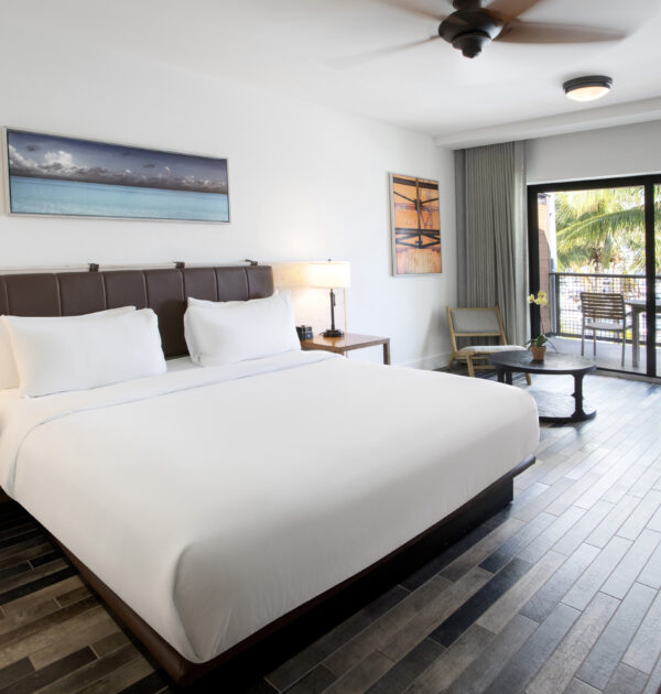 Spacious king room with bed, desk, and balcony.