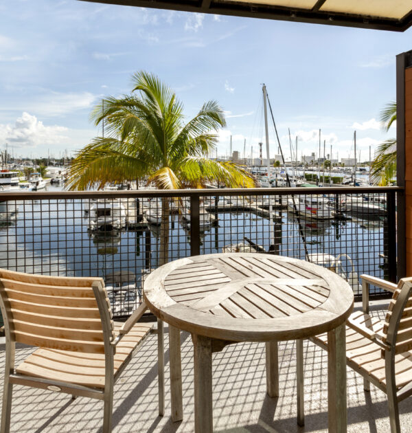Balcony with table, chairs, and palm tree views.