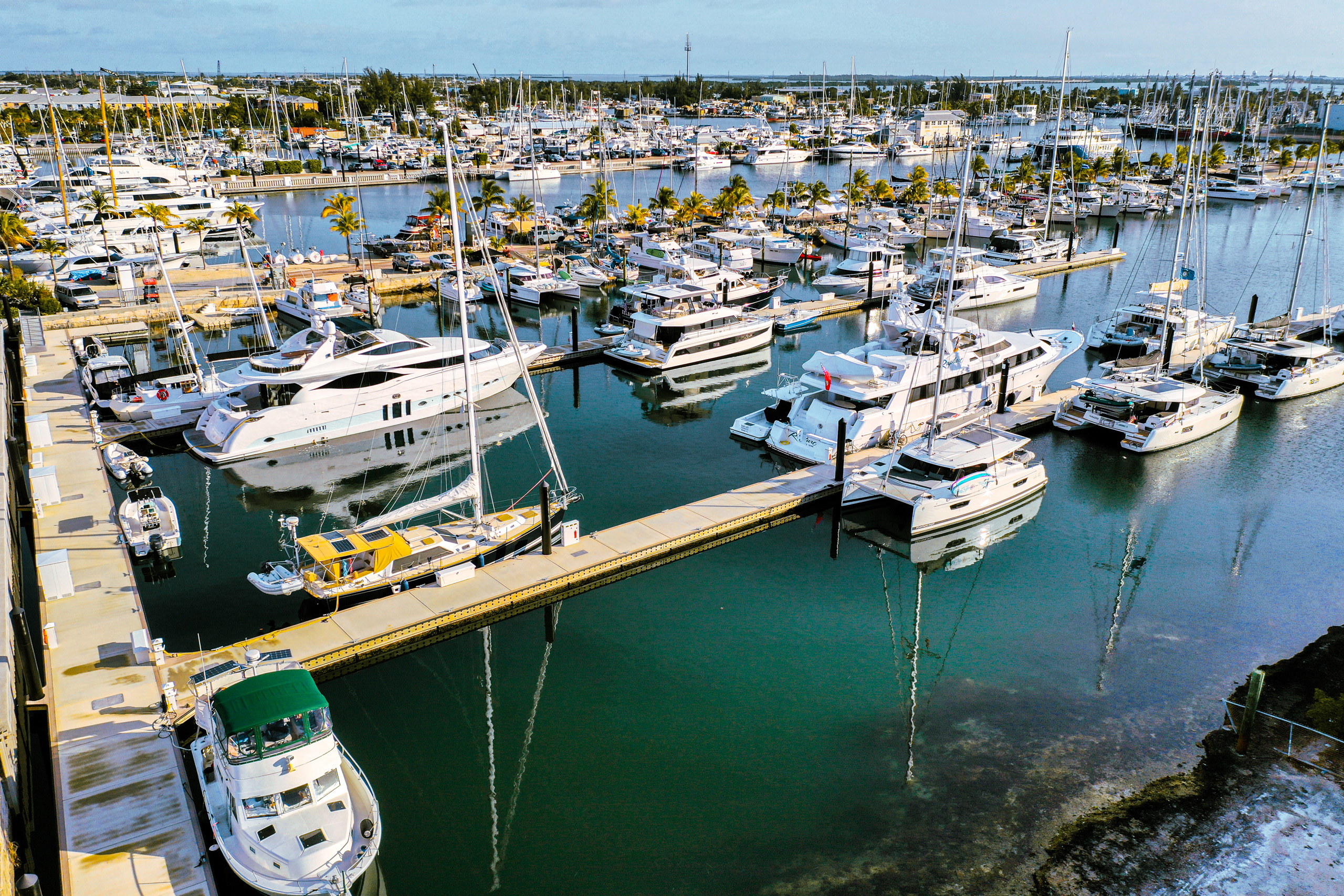 Marina view with yachts and sailboats under clear sky.
