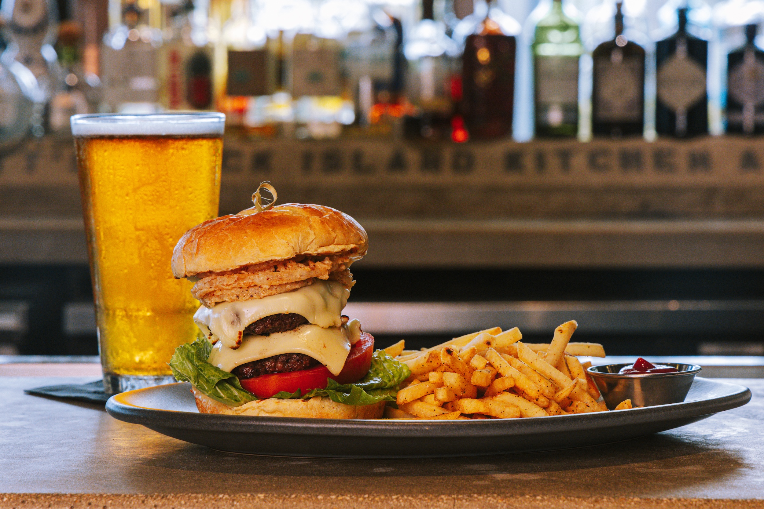 stacked burger served with fries and beer