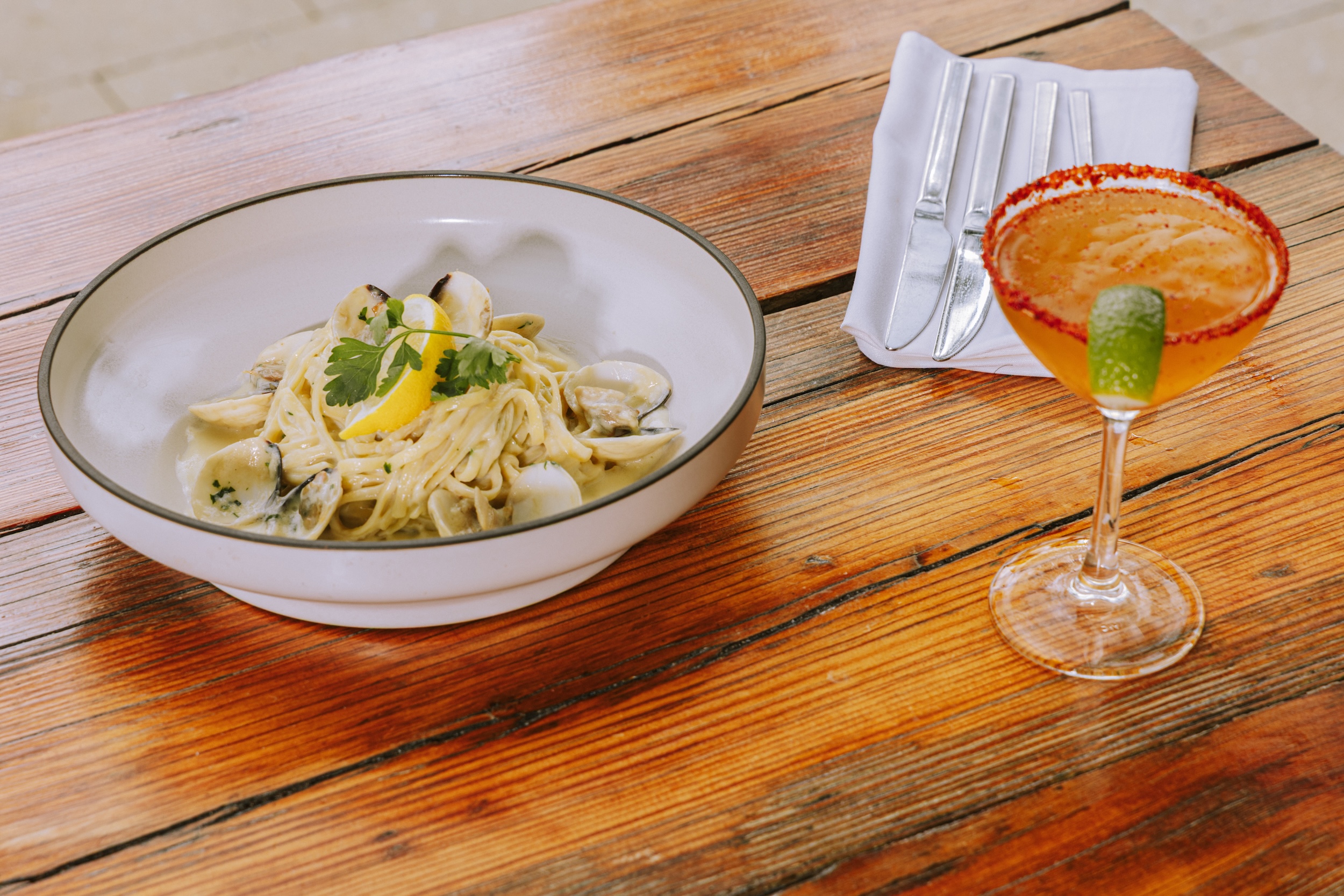 pasta dish accompanied by orange cocktail